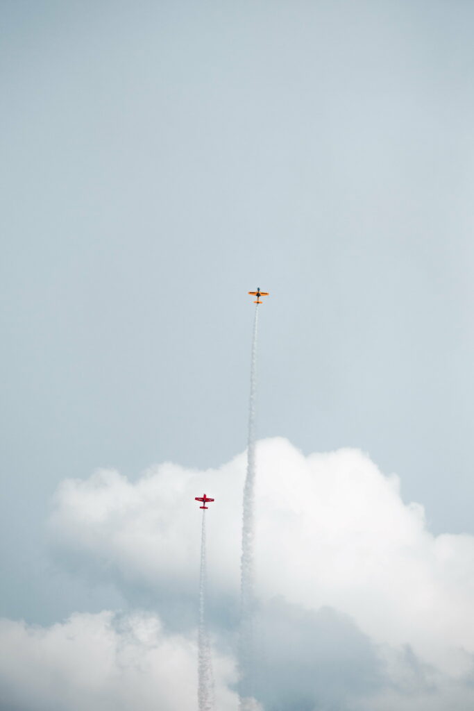 Synchronized Flight: Two Planes Ascend Through a Clear Blue Sky Wallpaper