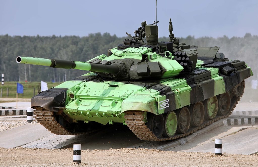 T-72B3 tank with green black camouflage on dusty military training ground concrete obstacle Wallpaper