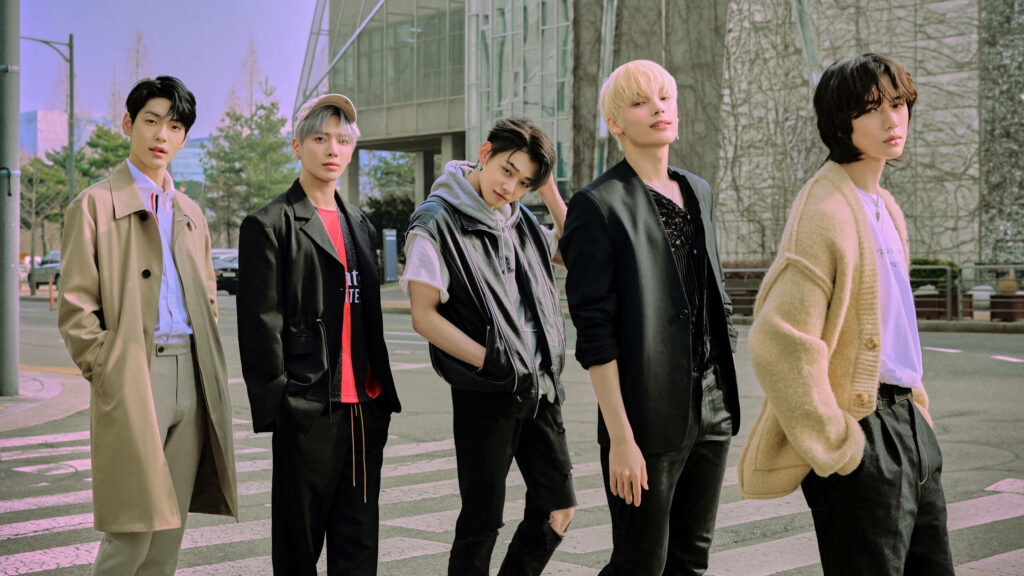 TXT's Fashionable Stroll: Members Taehyun, Soobin, Yeonjun, Beomgyu and Huening Kai Pose on a Pedestrian Lane Wallpaper