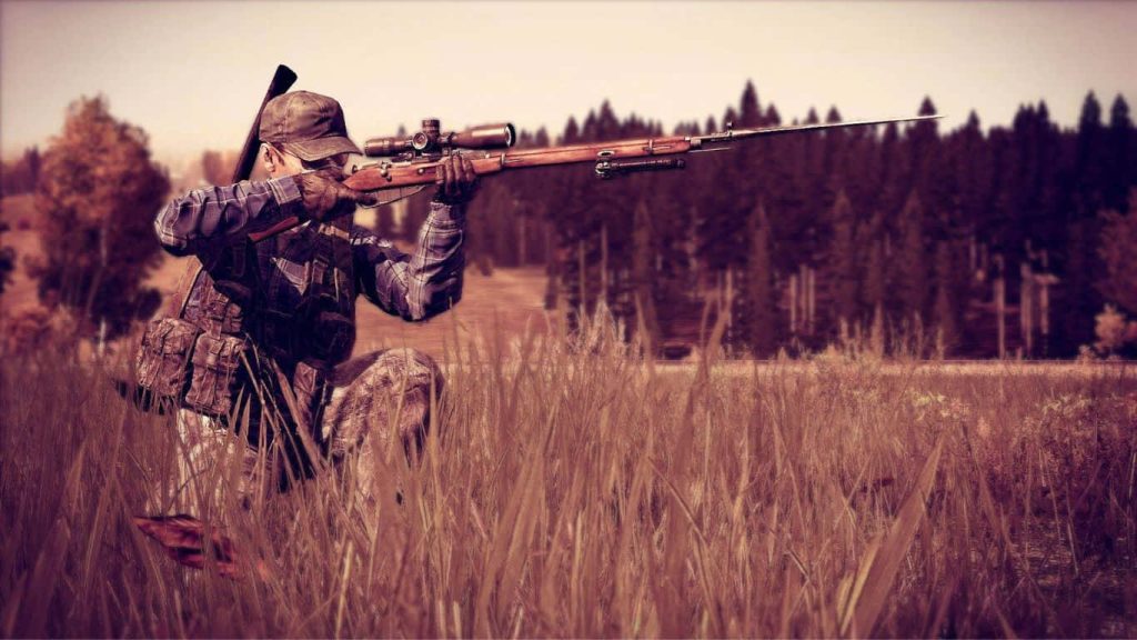 Tactical survivor kneeling in grass aiming Mosin-Nagant rifle with bayonet forest wallpaper background