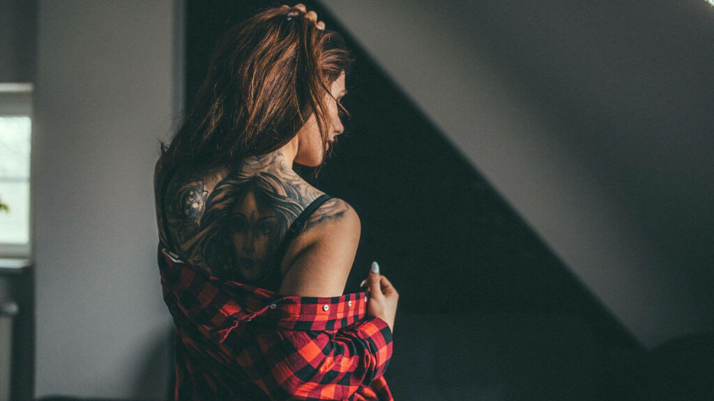 Inked Beauty: Brunette Girl With Checkered Polo and Tattoo Wallpaper
