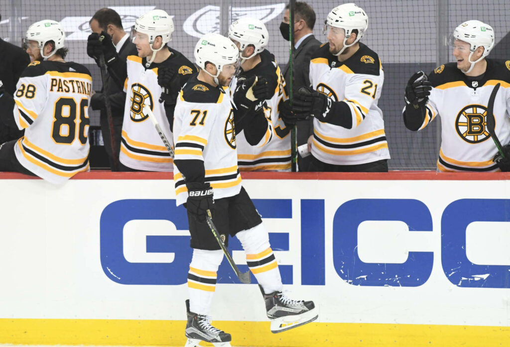 Dynamic Boston Bruins left winger Taylor Hall skating in black gold white uniform with teammates Wallpaper