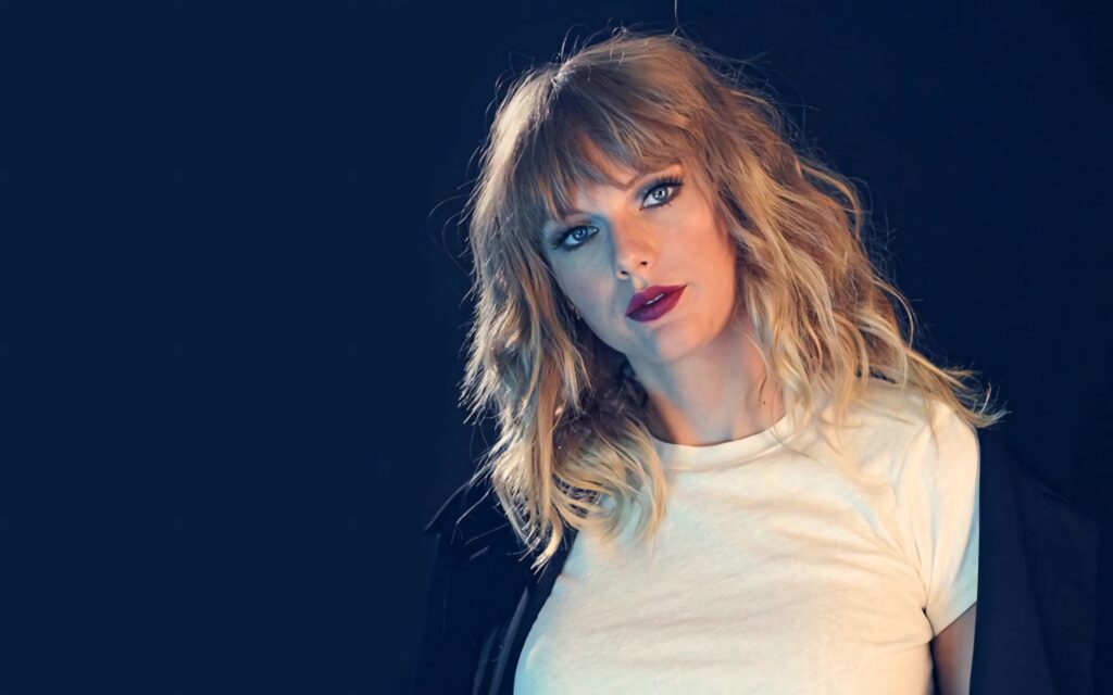 Taylor Swift with messy hair and confident expression bold stylish wallpaper background
