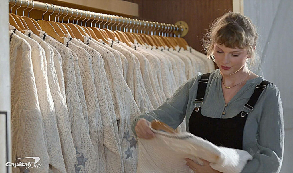 Taylor Swift choosing a cozy sweater in organized wardrobe showcasing casual charming style wallpaper
