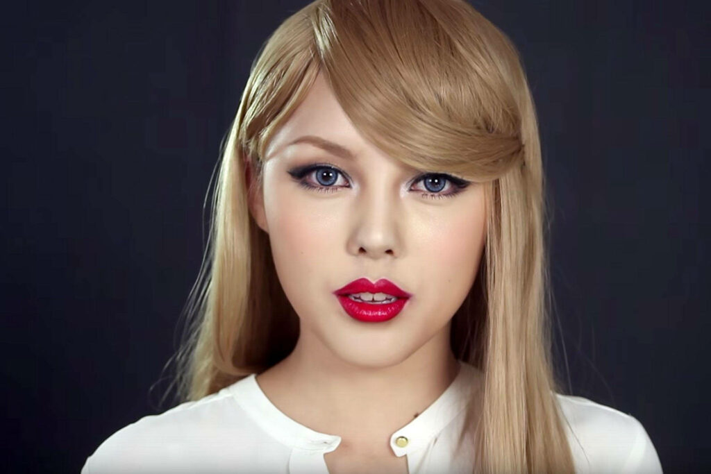 Taylor Swift with iconic red lips and bold eye makeup in elegant fan wallpaper background