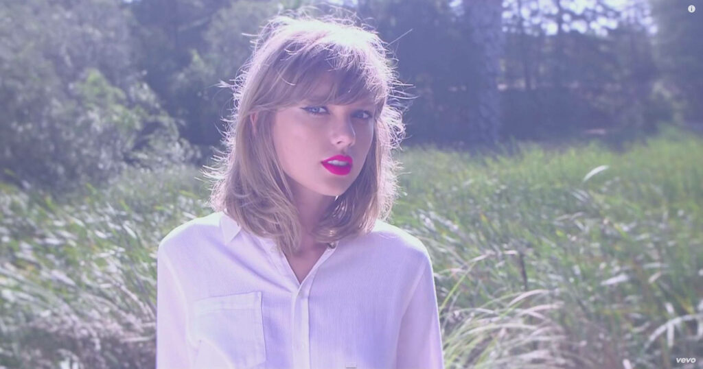 Taylor Swift in sunlit field with bright red lips white blouse angelic beauty serene wallpaper