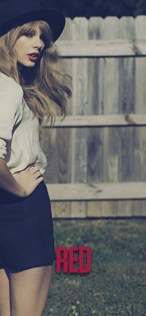 Taylor Swift in vintage outfit by wooden fence with bold Red Taylor's Version 2012 text wallpaper