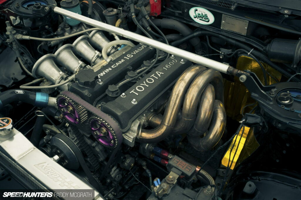 Detailed Toyota 4A-GE engine with purple HKS cams and Techno Pro Spirits badge AE86 bay Wallpaper