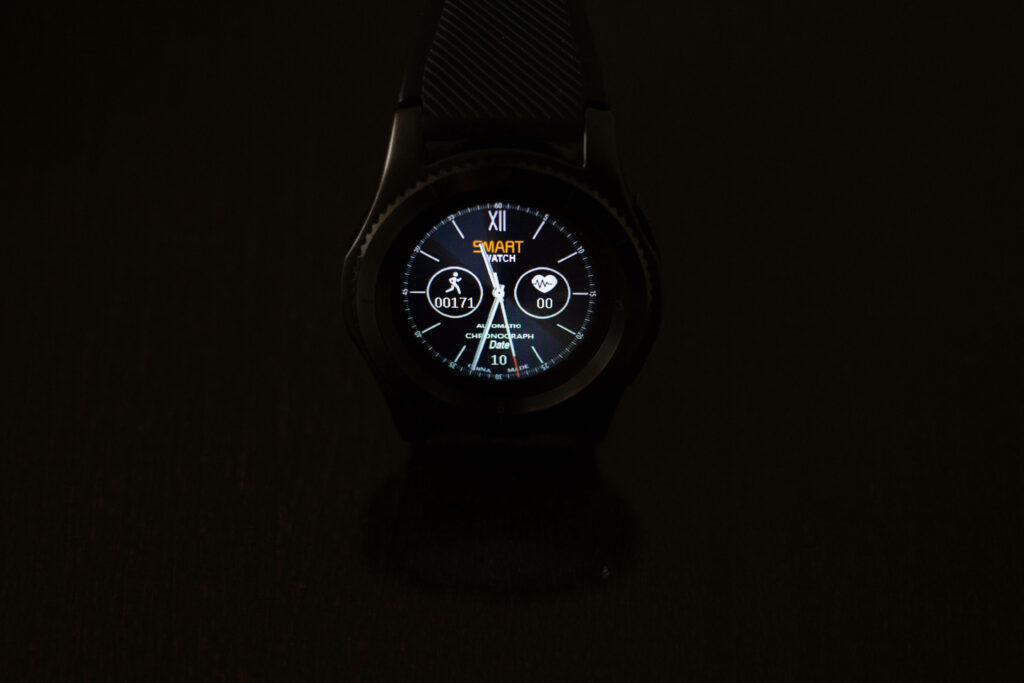 Futuristic Fitness Companion: Stylish Smartwatch Embraced by Jet-black Aesthetics Wallpaper