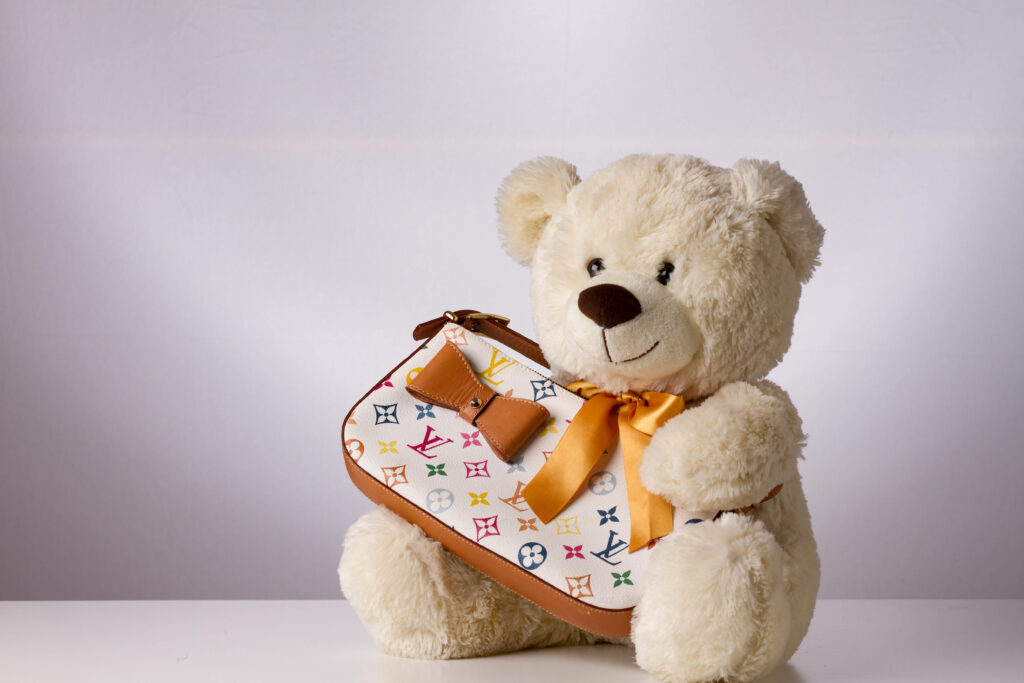 The Stylish Teddy Bear with a Branded Bag in a Elegant Setting Wallpaper