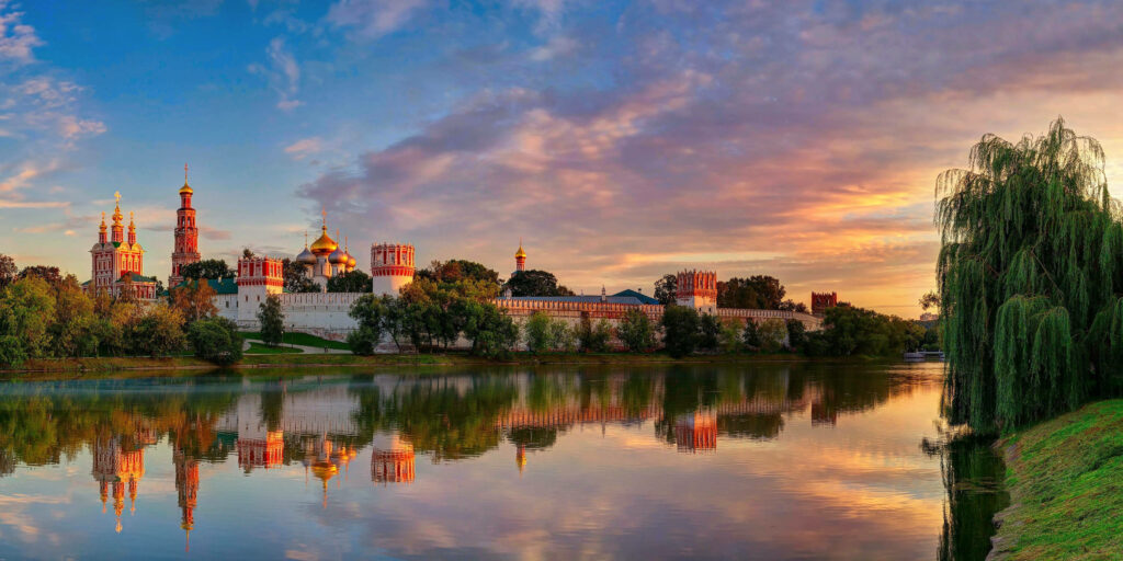 Temple of Gods Moscow reflection on calm lake at vibrant sunset serene cityscape wallpaper