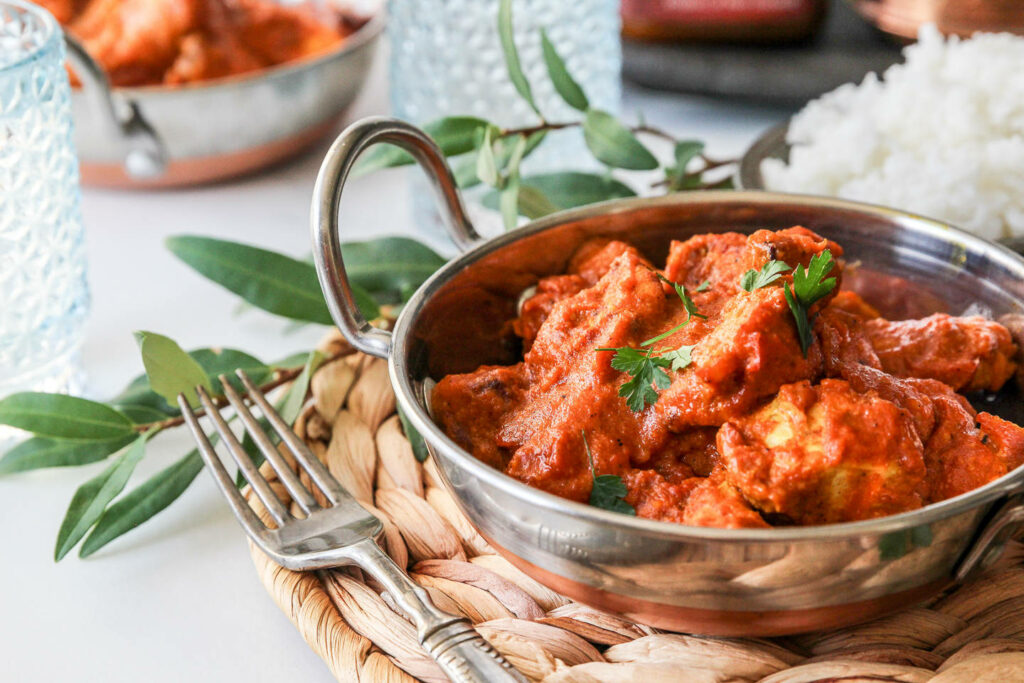 Tempting Butter Chicken Close-Up in Traditional Bowl | Elegant Dining Decor Wallpaper