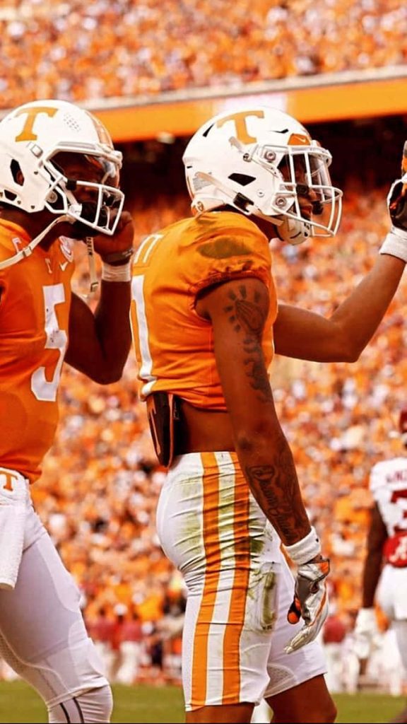 Tennessee Volunteers quarterback Hendon Hooker in vibrant orange gear on football field wallpaper
