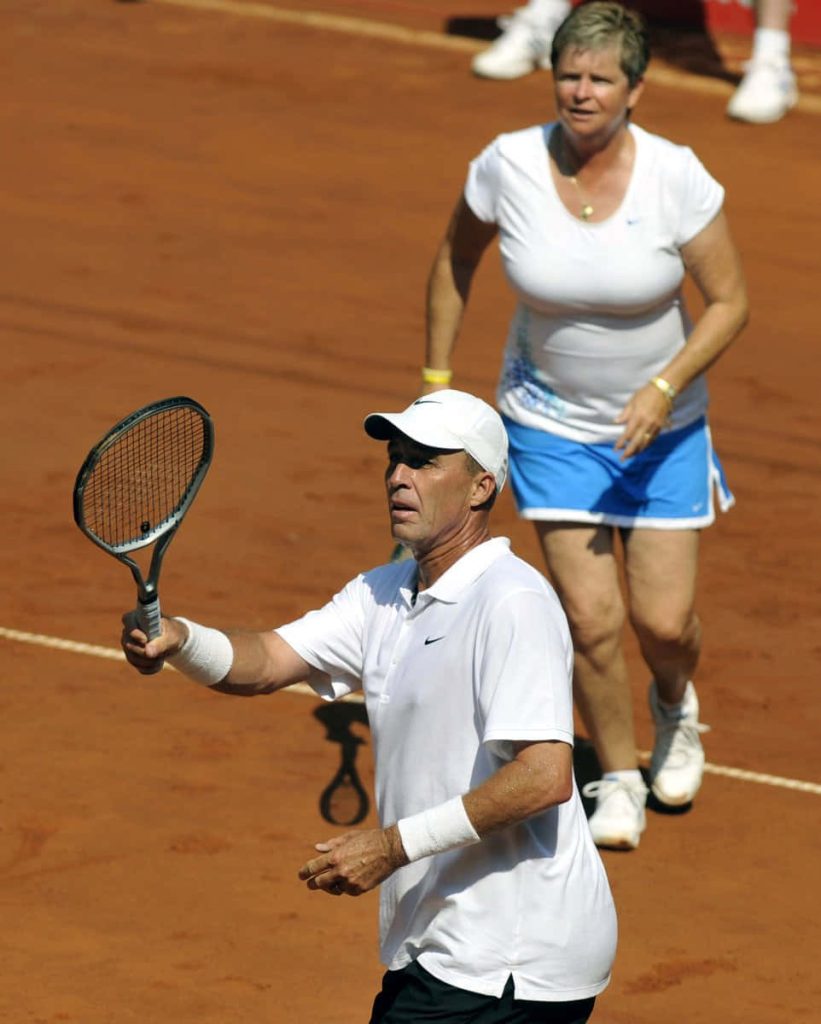 Tennis legends Ivan Lendl and Pam Shriver competing on vibrant red clay court in action shot Wallpaper