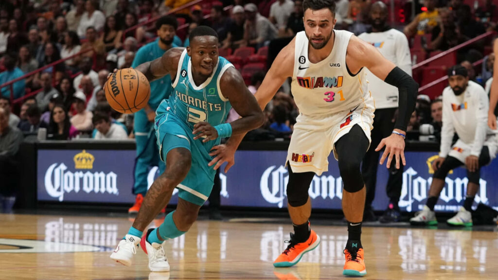Terry Rozier Charlotte Hornets drives past Miami Heat defender vibrant basketball action wallpaper