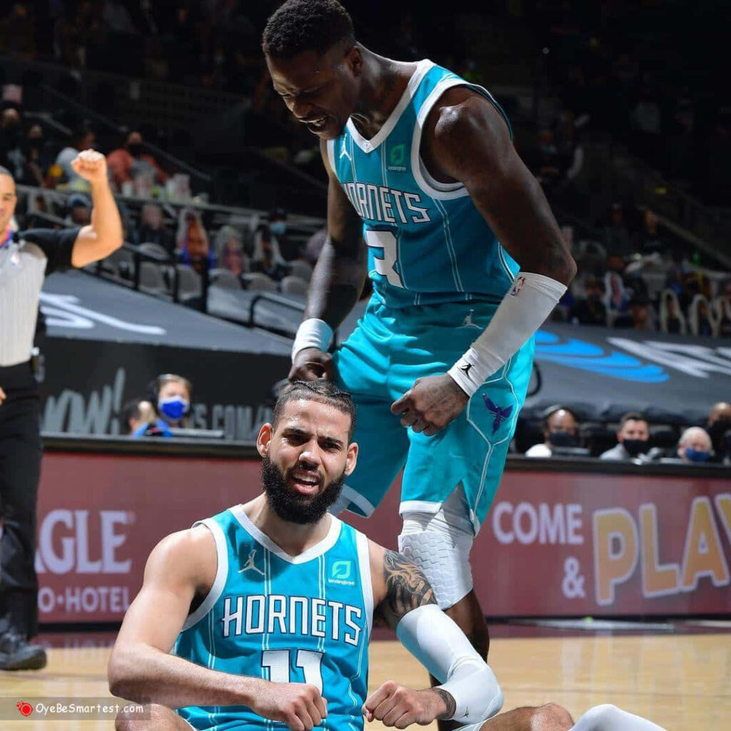 Terry Rozier and Cody Martin celebrate in vibrant teal Hornets uniforms on basketball court Wallpaper