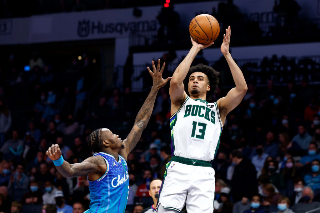 Terry Rozier defending Milwaukee Bucks jump shot in vibrant Charlotte Hornets basketball game Wallpaper