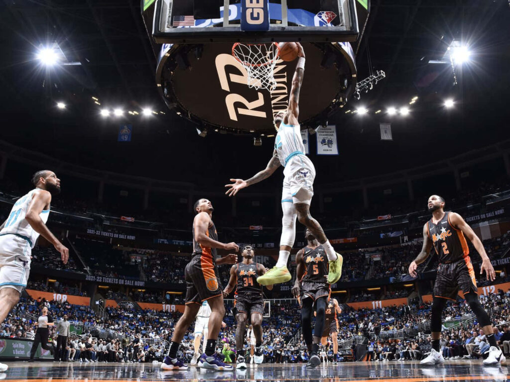 Terry Rozier soars for a dunk in intense NBA game with vibrant uniforms and dramatic lighting Wallpaper