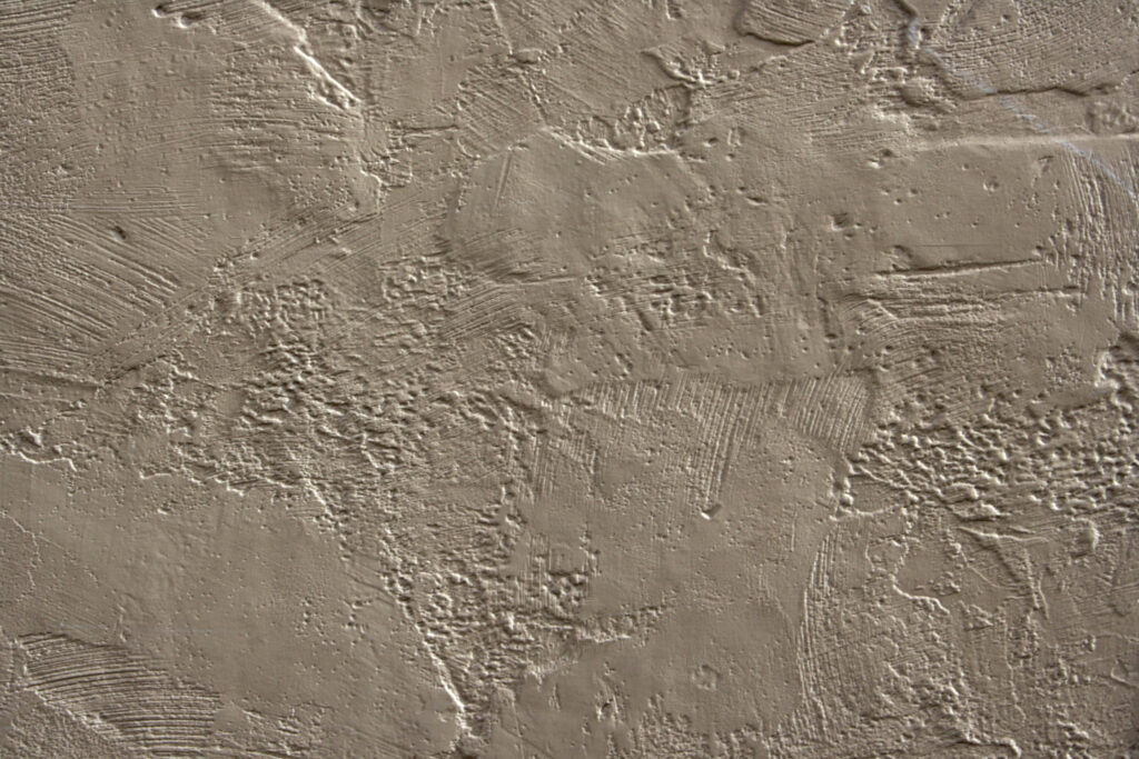 Beige Stucco Wall Close-Up: Textured Surface for Wallpaper Background