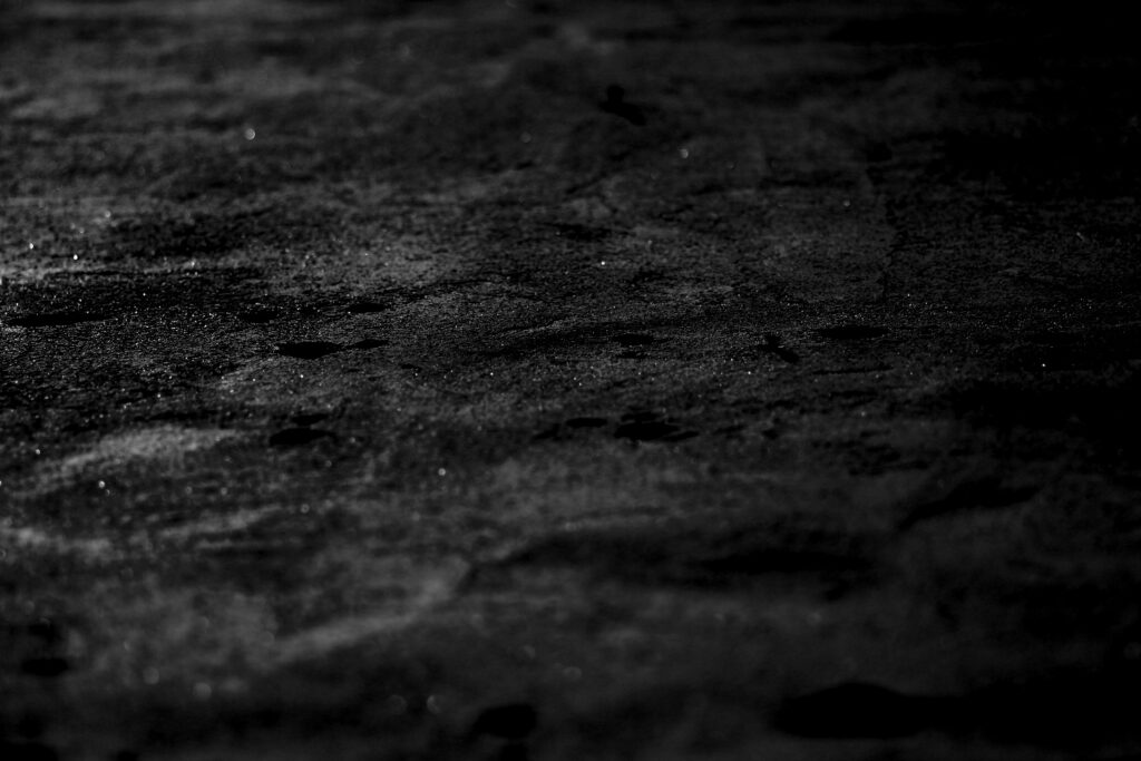 Textured Black Wet Surface Wallpaper: Moody Aesthetic with Reflections