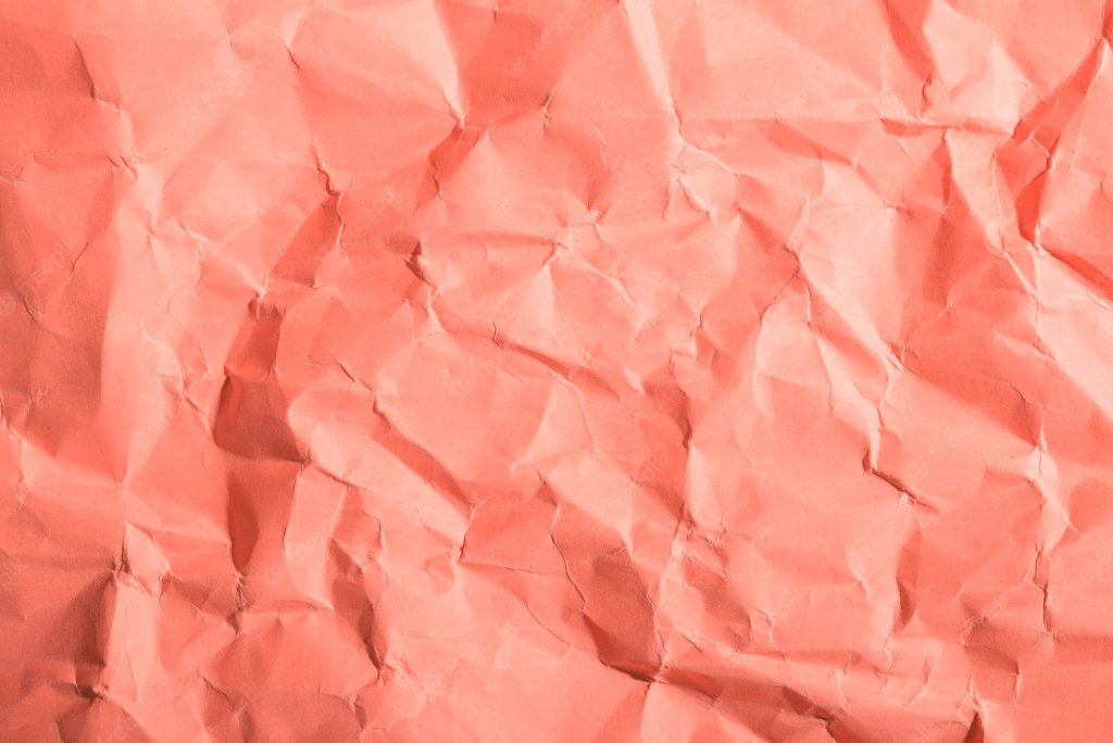 Textured coral crumpled paper wallpaper with intricate folds and soft lighting for modern design