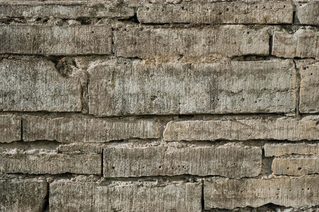 Textured Stone Hollow Block Wall: Rugged, Weathered Wallpaper Background