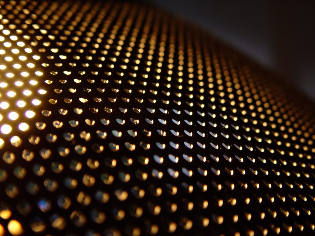 Textured Wallpaper with Glowing Perforations on Dark Background