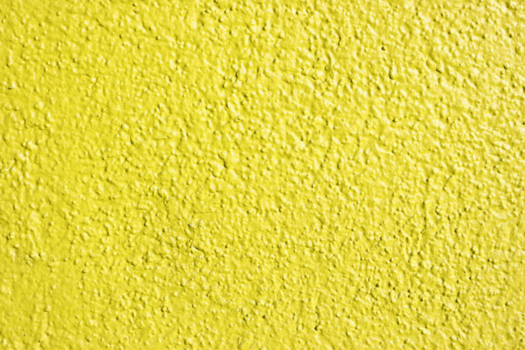 Textured Yellow Painted Wall Close-Up - Rough Wallpaper Background