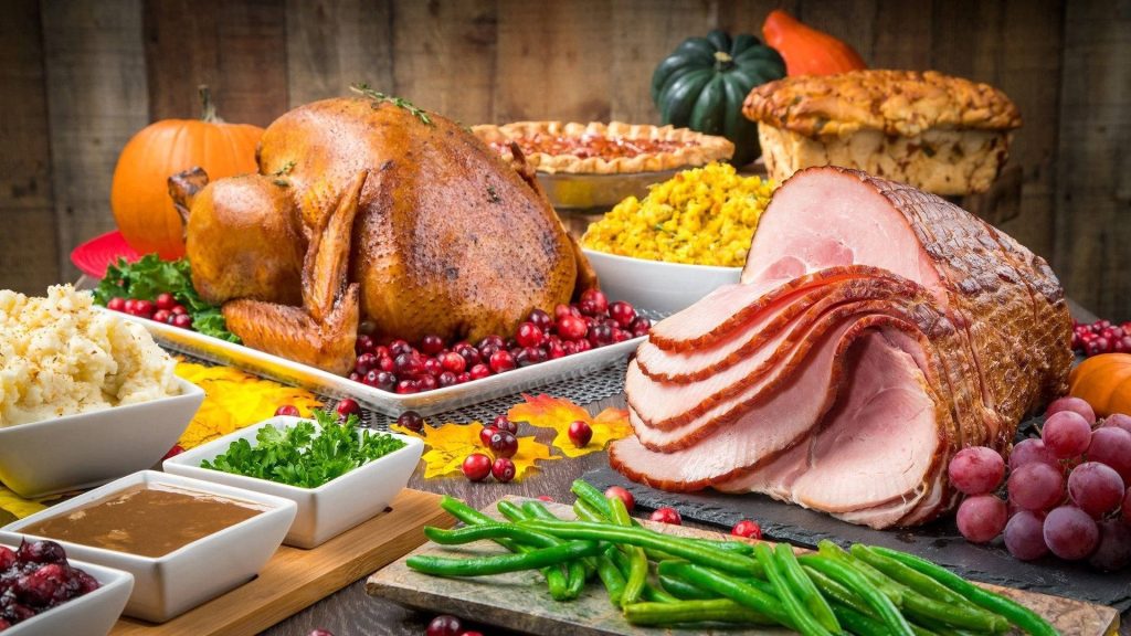 Thanksgiving feast wallpaper with golden turkey glazed ham mashed potatoes green beans cranberries