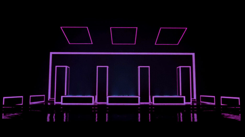 The 1975's Mesmerizing Neon Spectacle: A Captivating Backdrop Set with their Iconic Rectangular Sign Wallpaper