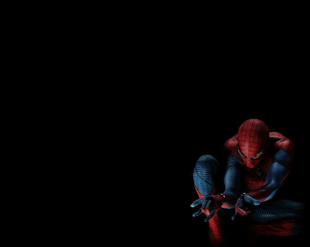 The Amazing Spiderman crouching in iconic suit ready to shoot webs on dark HD wallpaper background