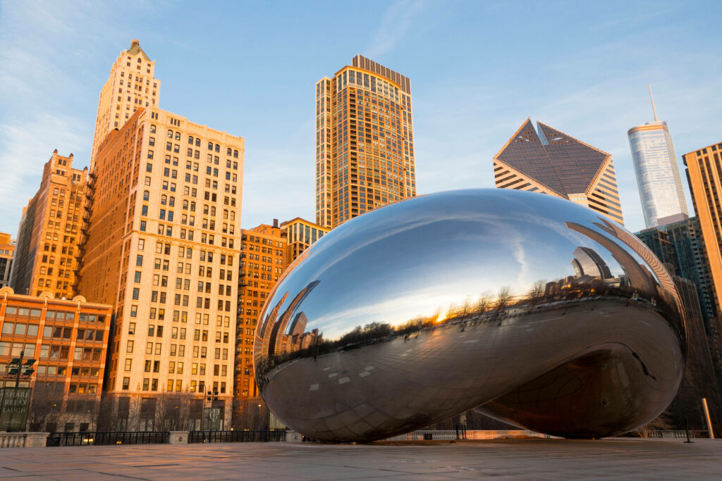The Bean in Chicago reflecting clear sky and skyscrapers in warm afternoon sunlight wallpaper