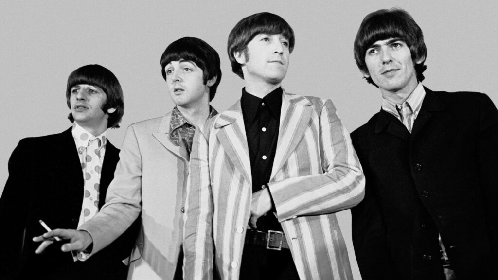 The Beatles iconic group photo with John Lennon Paul McCartney George Harrison and Ringo Starr in suits Wallpaper