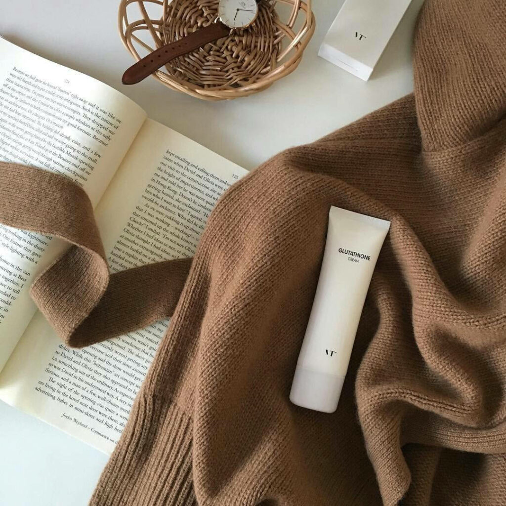 Essentials of the Beige Minimalist: A Delicate Collection of a Book, Sweatshirt, Sunscreen, and Watch on a Neutral Background Wallpaper