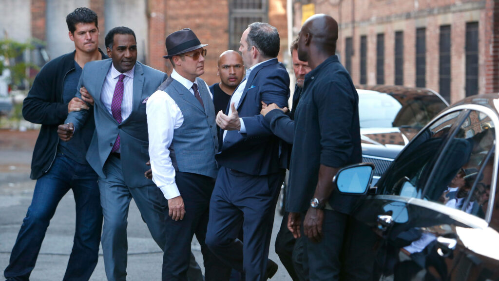 James Spader and cast intense city street confrontation scene from The Blacklist wallpaper background