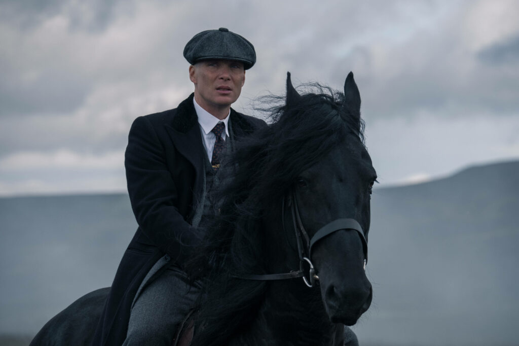 The Dapper Gangster: Captivating Tommy Shelby on His Majestic Black Stallion - Spectacular Peaky Blinders 8k Backdrop Wallpaper