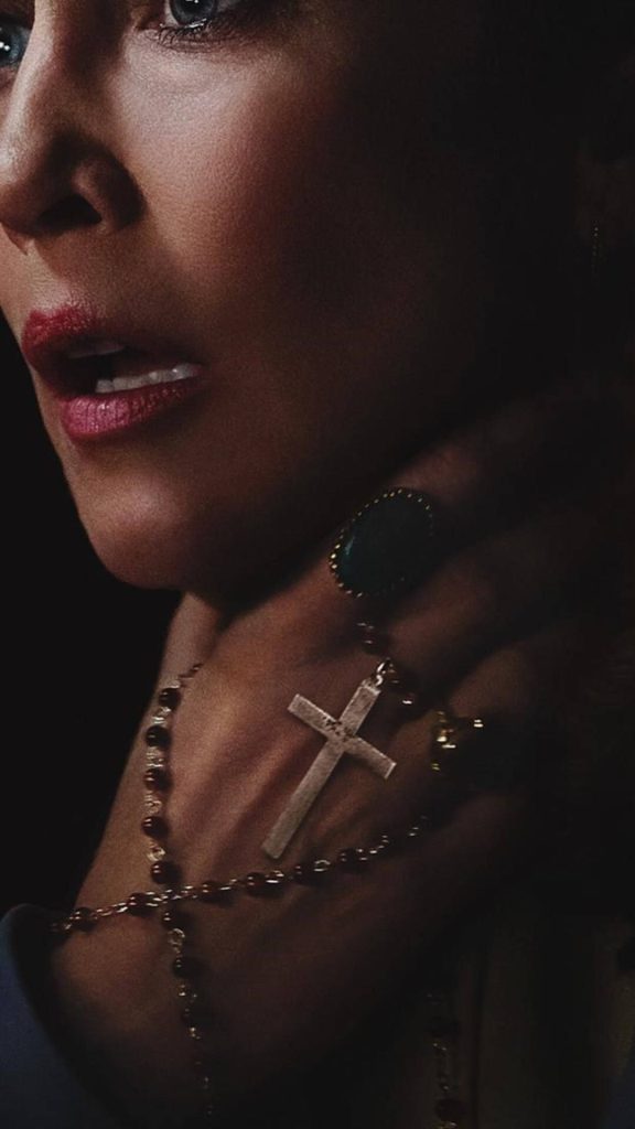 Vera Farmiga as Lorraine Warren clutching rosary cross dark moody The Conjuring wallpaper