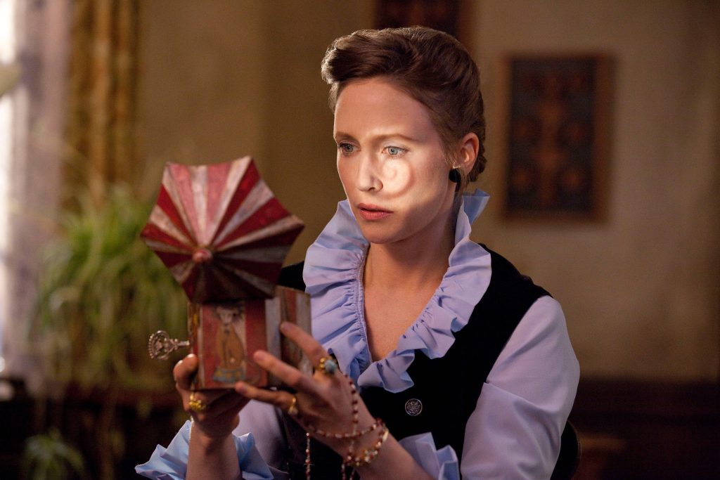 Vera Farmiga as Lorraine Warren studies eerie vintage carousel music box in The Conjuring wallpaper