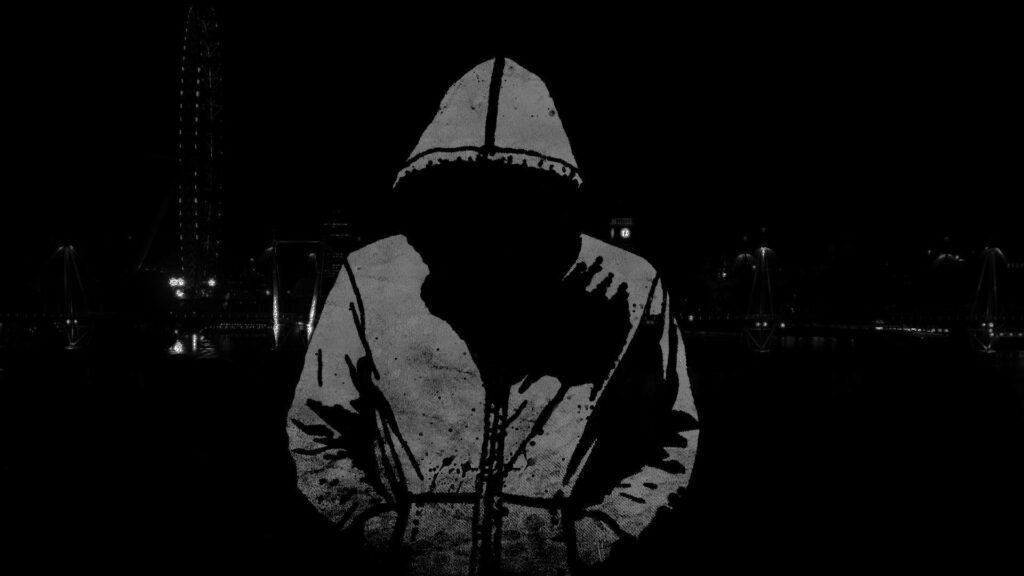 The Dark Streets' Hacker: A Hooded Man in a Cityscape Wallpaper