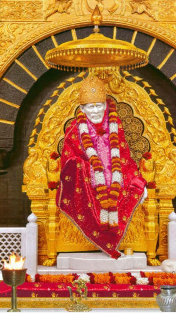 Divine Majesty: Sai Baba's Glorious HD Statue on Golden Throne with Red Cloth and Floral Adornments - Breathtaking Background Image Wallpaper