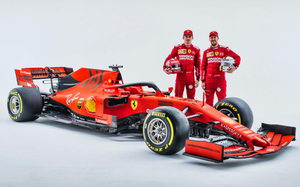 The Dynamic Duo: Sebastian Vettel and Charles Leclerc Embrace the Excitement of F1 Racing in a Sleek White Oasis Wallpaper