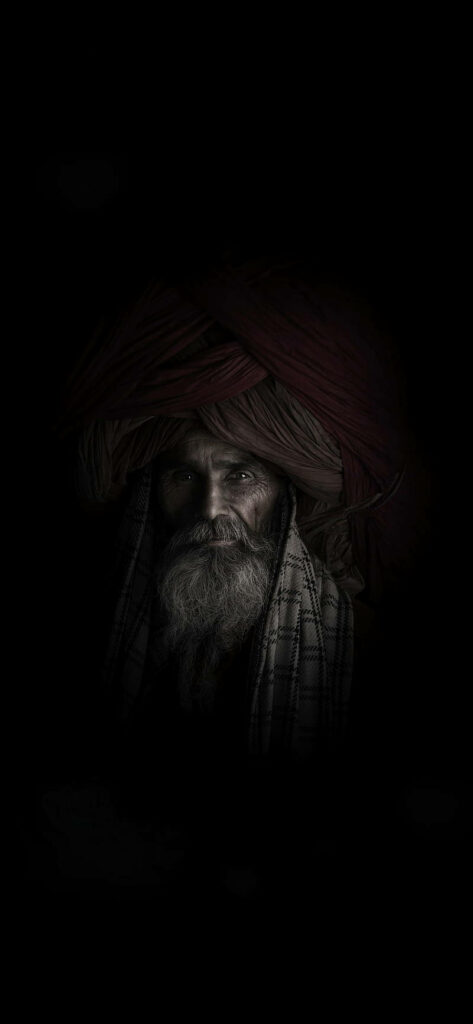 The Shadowed Gaze: Captivating Aghori Mystic Engulfed in Darkness Wallpaper