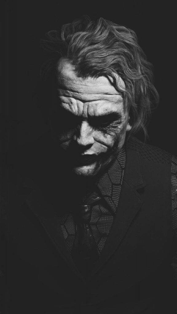 Shadowed Smile: Captivating Joker Phone Background featuring Heath Ledger Wallpaper