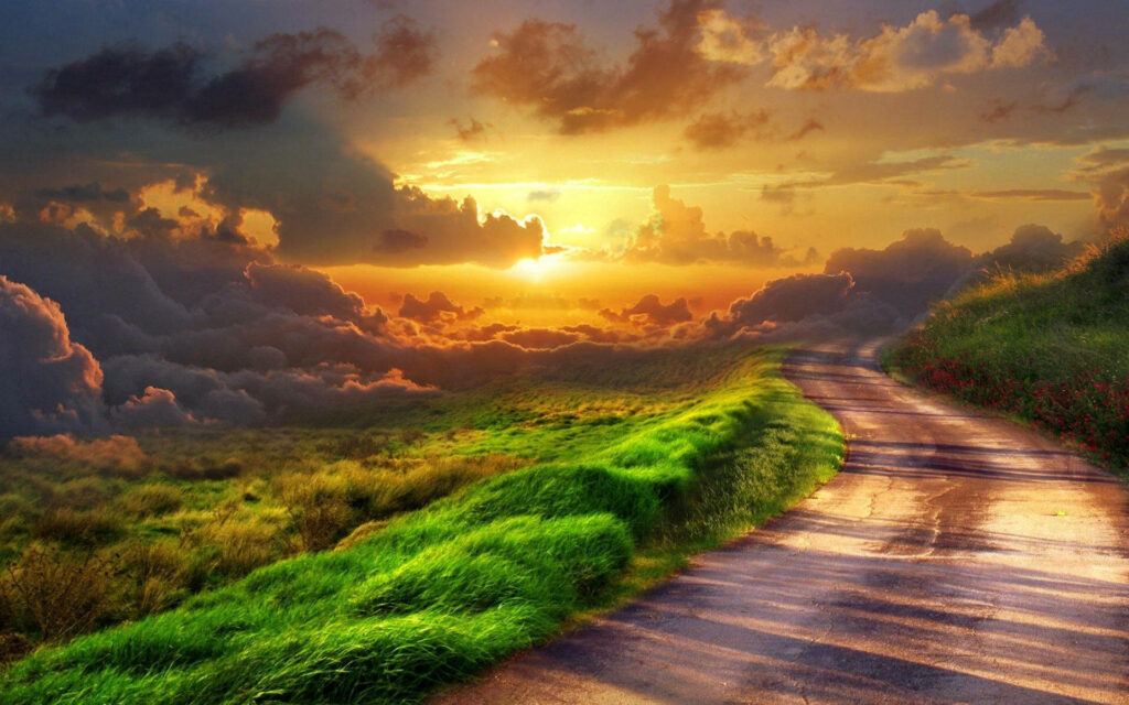 Winding path through lush green hills at sunset under dramatic fluffy clouds scenic nature wallpaper