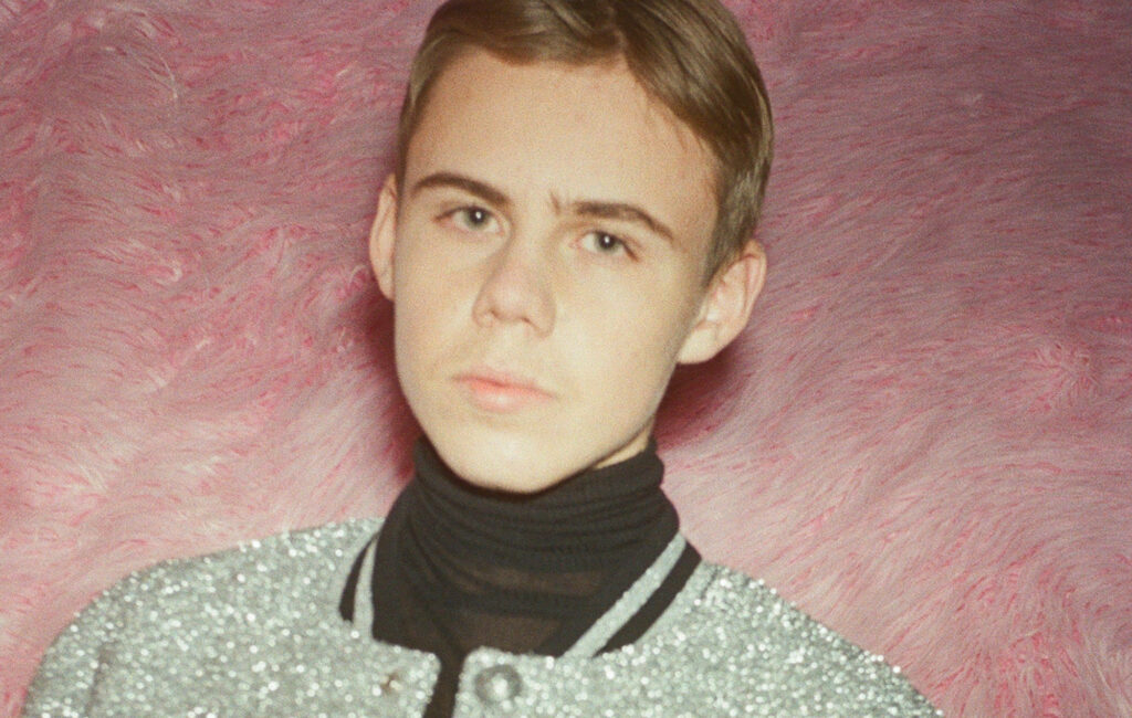 The Kid LAROI Wallpaper: Stylish Aussie Rapper on Pink Background