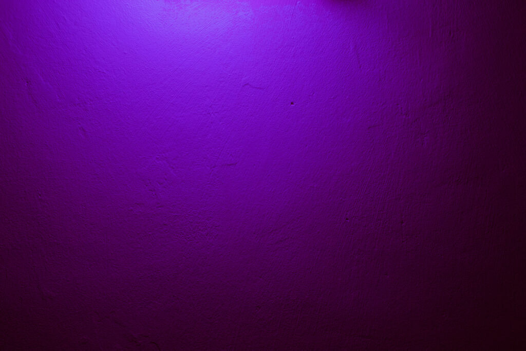 Vibrant deep violet textured wall with dramatic spotlight and moody gradient background wallpaper