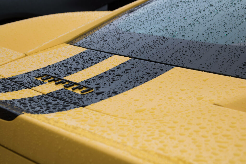 Speeding Enchantment: Glowing Ferrari Dances on Rain-Kissed Road Wallpaper