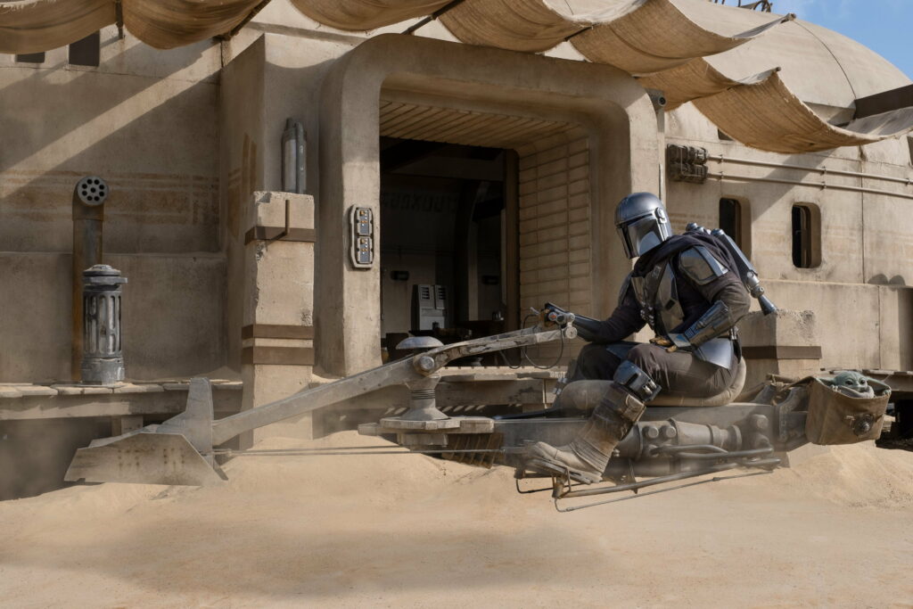 The Lone Bounty Hunter: Riding the Speeder Bike through the Galaxy - The Mandalorian Season 2 Wallpaper