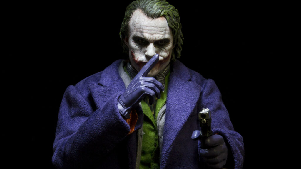 Sinister Grin: Joker, the Menacing Nemesis of Batman, Brandishing His Firearm in 4k Ultra HD Wallpaper