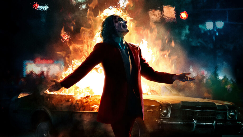 The Fiery Ballet: Joaquin Phoenix's Joker Charismatically Dances Amidst a Blaze Wallpaper